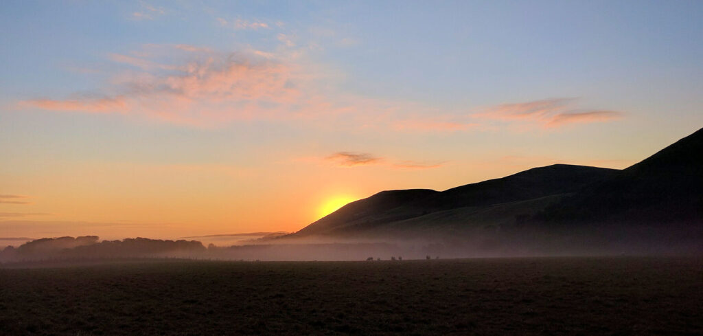 Sunrise over a volcanic landscape. From right to left, Yeavering Bell, White Law and Akeld Hill, near Kirknewton